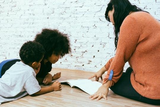 A mother and children reading a book