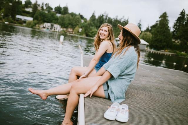 Two women sitting on a dock
