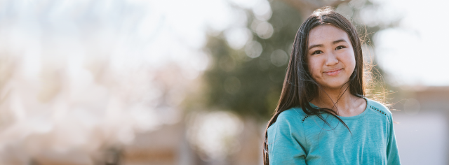 A young girl smiling outdoors
