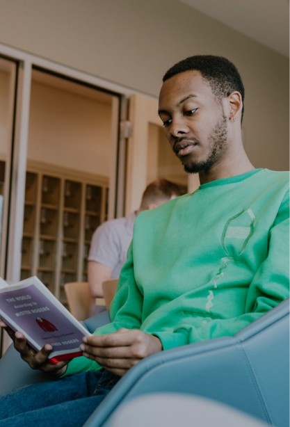 Image of a young man reading a book