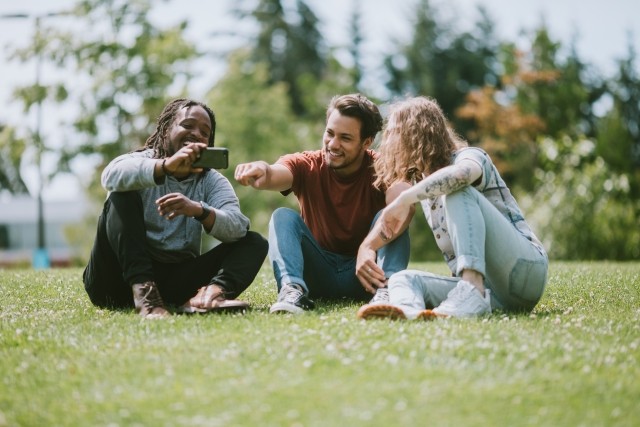 Friends in the park looking at a phone