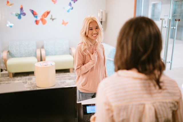 A patient checks in at reception on her first day