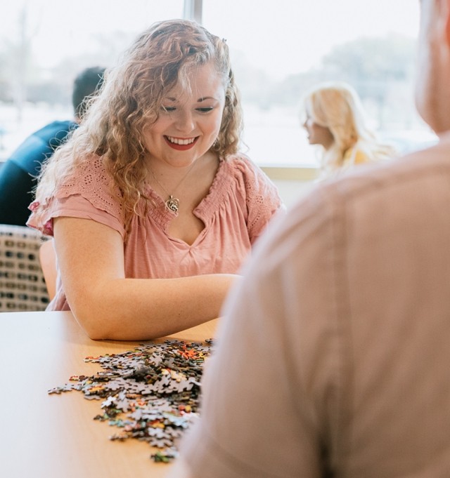 woman and man happily completing puzzle