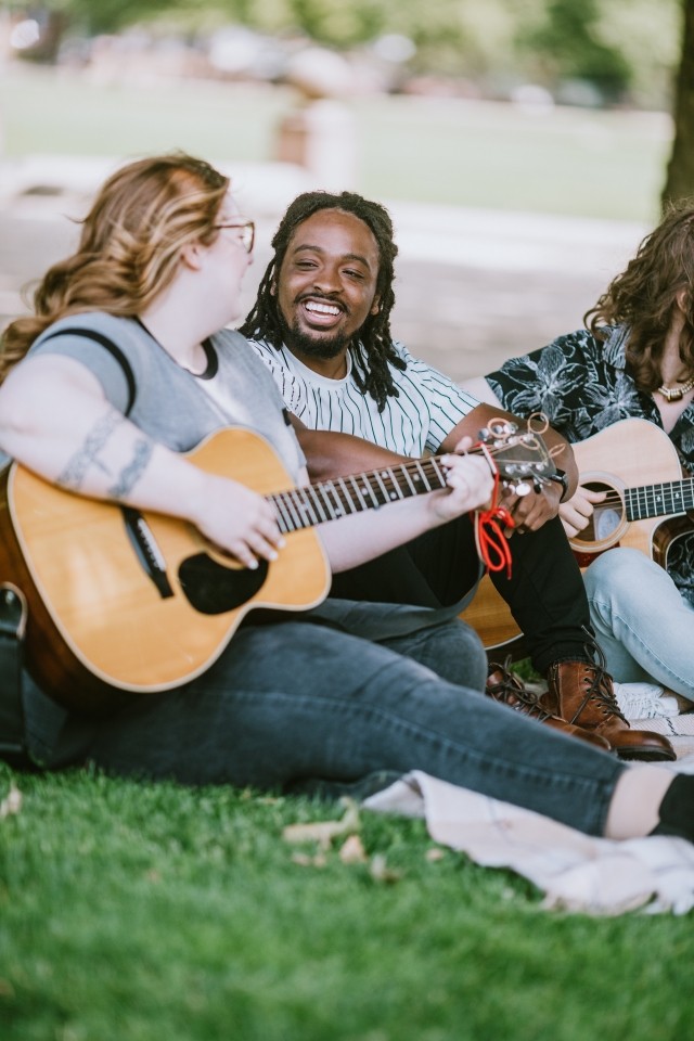 A group of friends plays music outdoors
