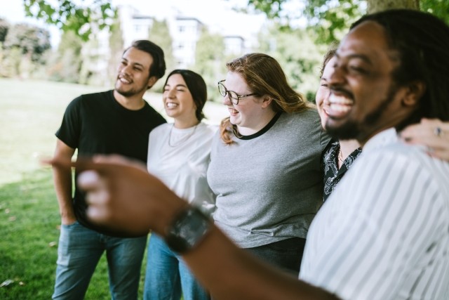 A group of friends laughing and talking outdoors