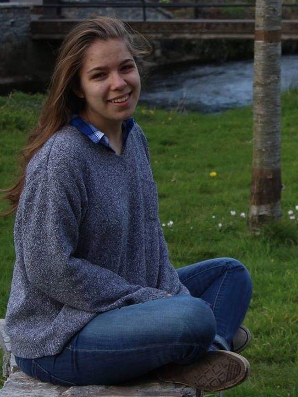 A woman sits outdoors