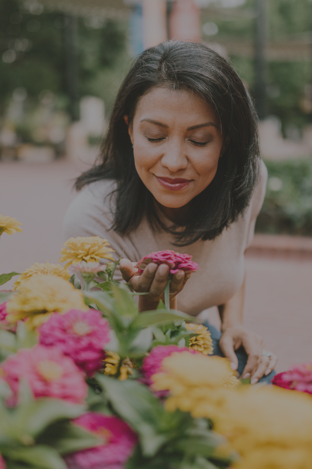A woman smells flowers outdoors