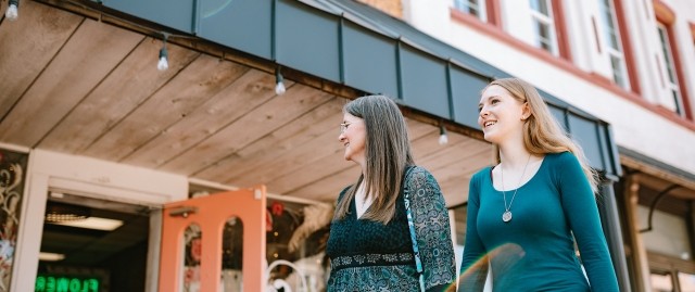An alum walks with her mother outdoors