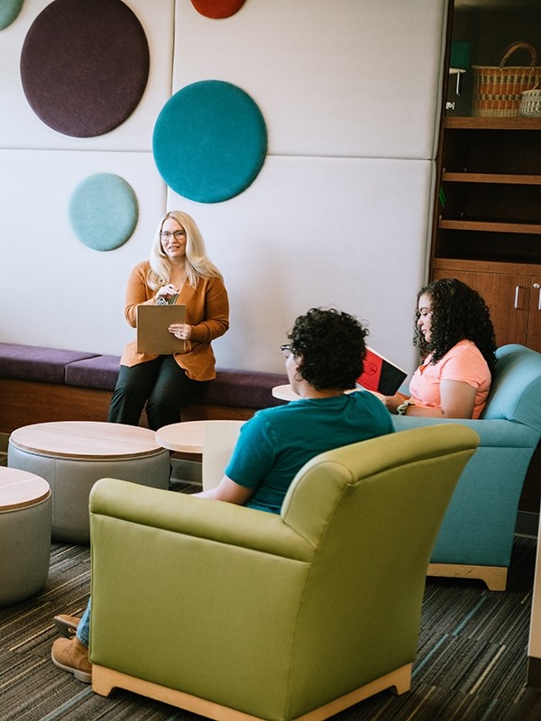 A group of adolescent patients works with a therapist in a  group environment