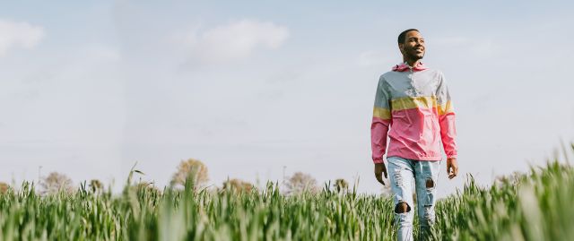 A man walks in a field in the sun