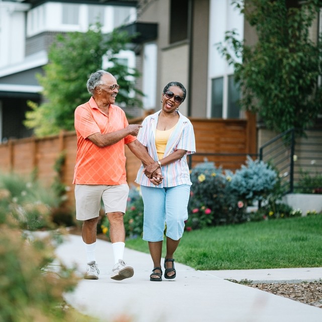 An older couple walks outdoors in their neighborhood