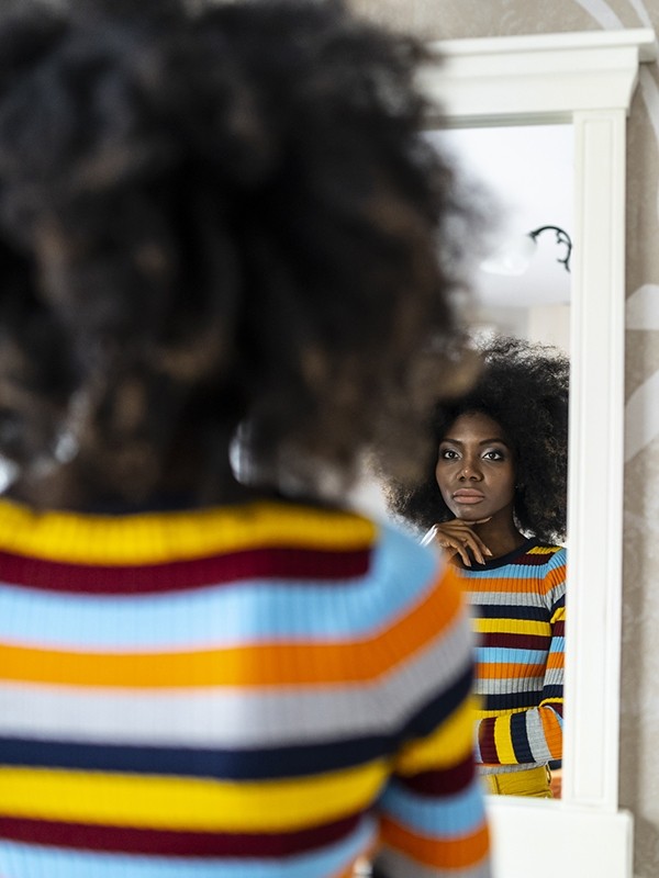 A woman looks in the mirror