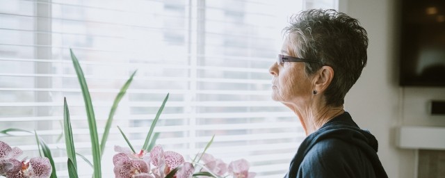 A woman looks out a window