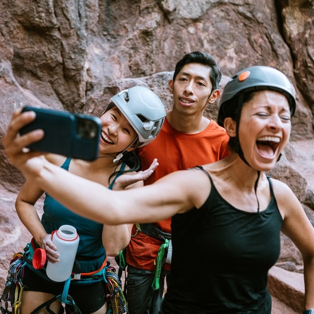 A group of rock climbers taking a selfie and laughing together