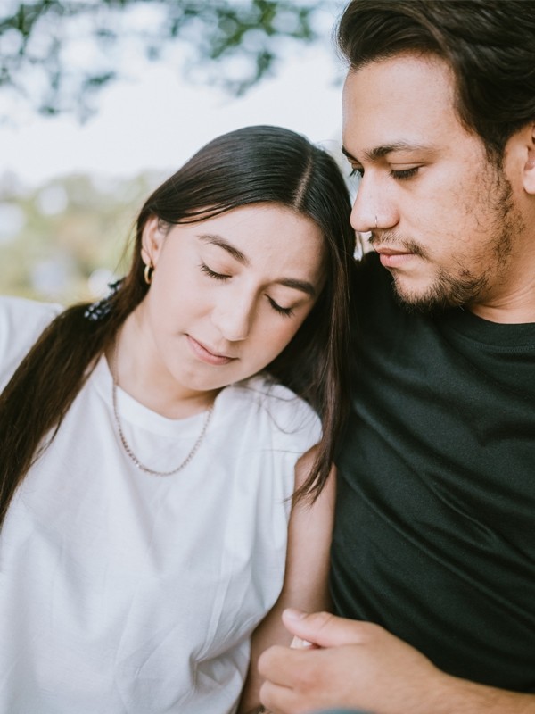 A man and woman sit on a park bench