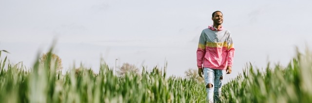 A man walks in a field in the sun