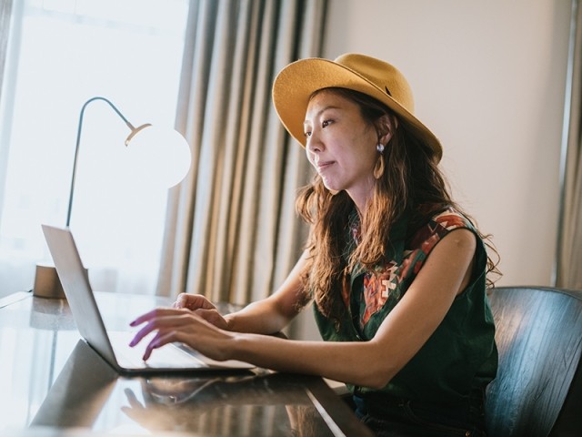 a woman works on a laptop