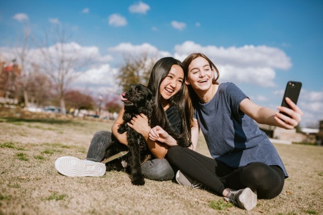 Two girls with a dog taking a selfie picture