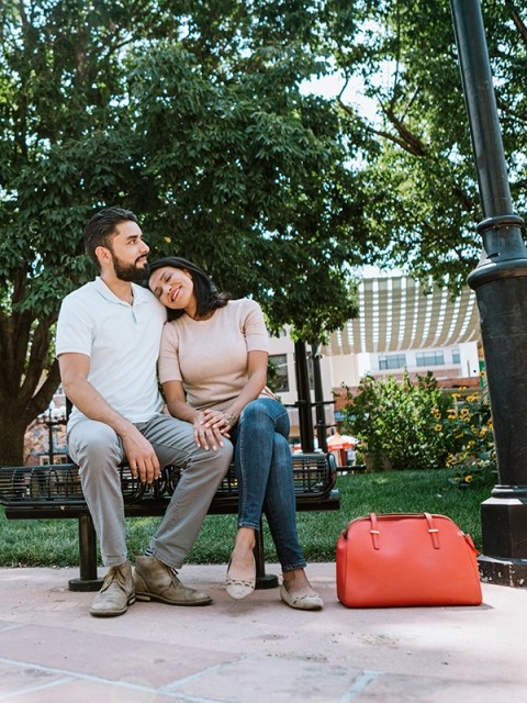 A couple sits on a bench outdoors